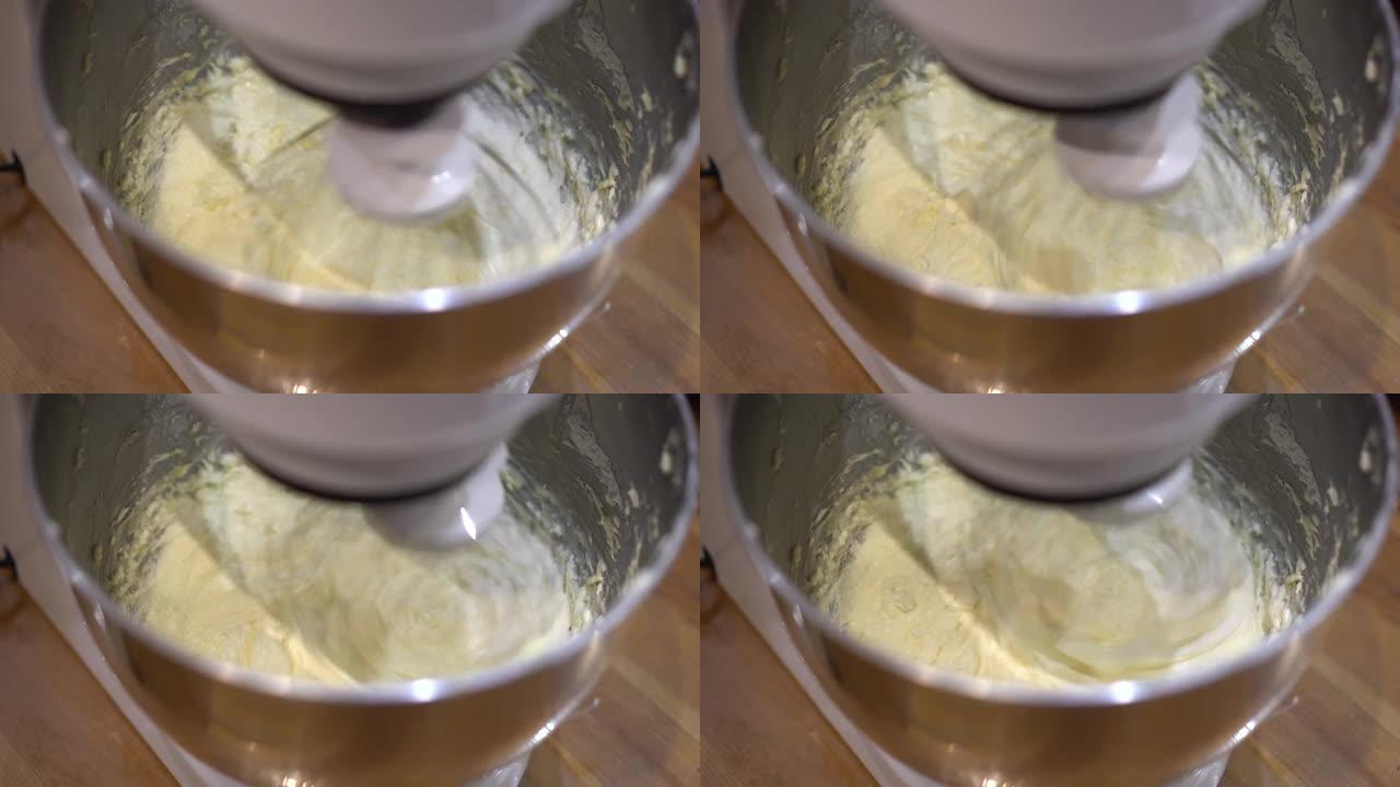 行星搅拌机击败了烹饪产品的奶油。厨房自动搅拌机。