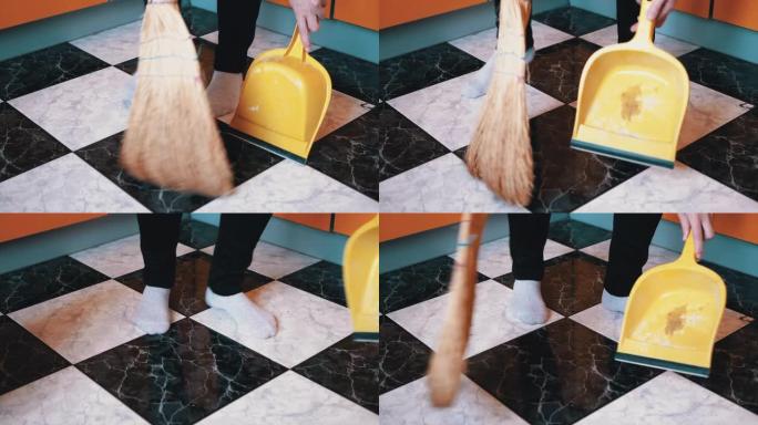 滑稽的女人穿着袜子在厨房里跳舞，用扫帚和铲子清扫地板