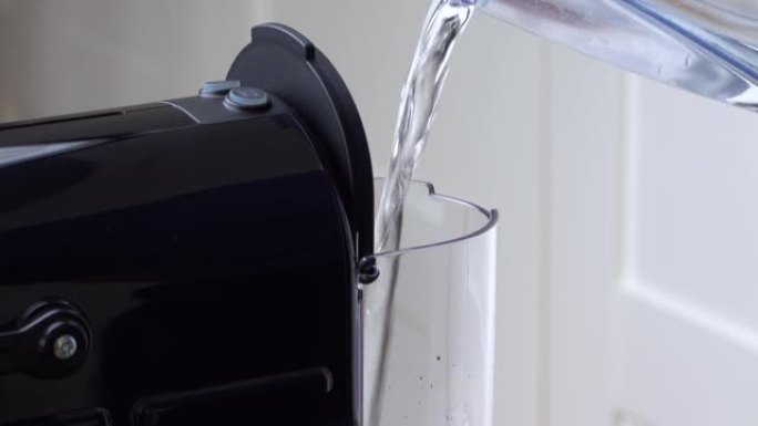 将纯净水倒入胶囊咖啡机中。