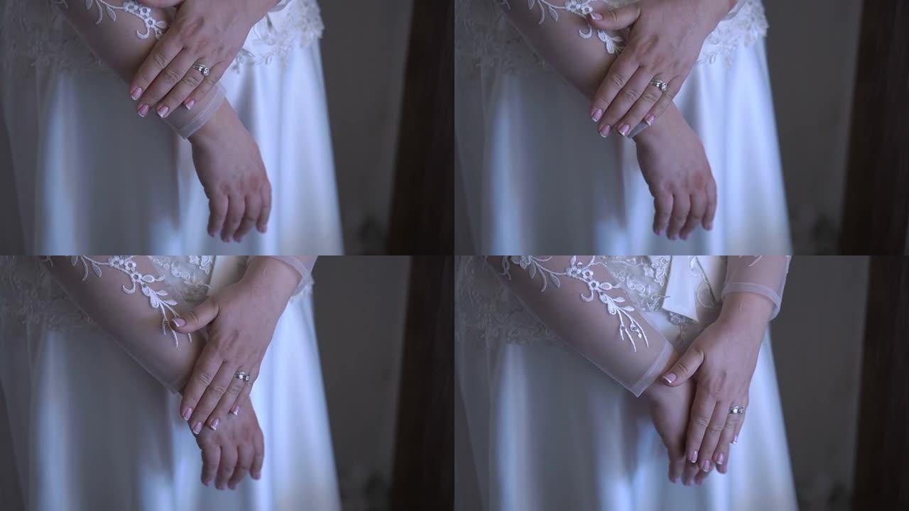 穿着白色连衣裙的美丽新娘的手