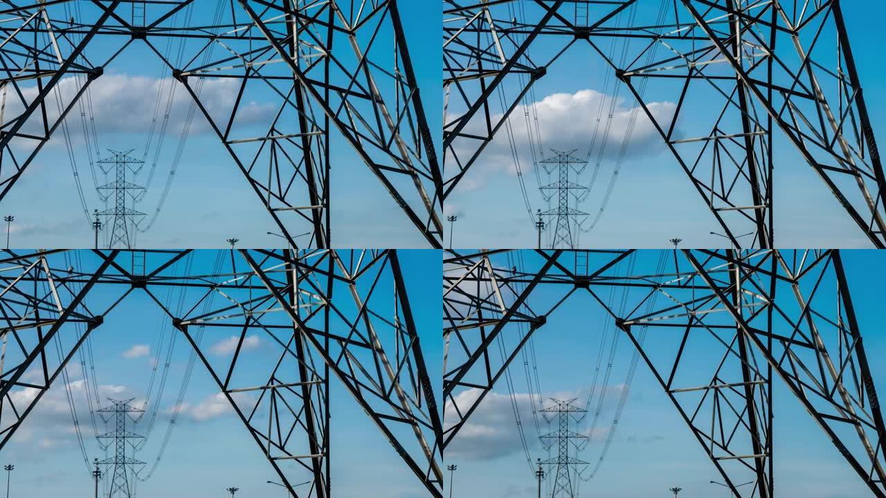 时间流逝的云穿过电线杆，高压电力塔。