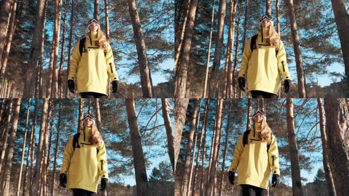 一个穿着黄色夹克，背着背包和滑雪板面具的女孩穿过森林