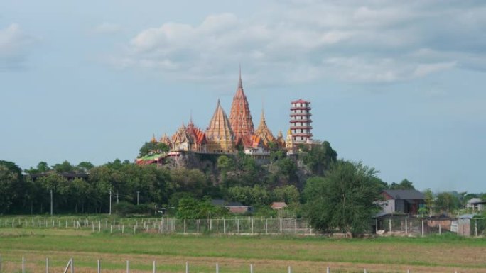 时光流逝的Wat tham sua或tiger cave temple，带有绿色的茉莉稻田，蓝天，阳