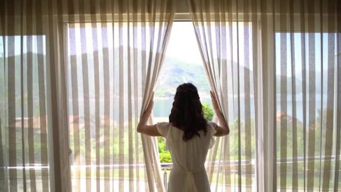 酒店房间里的新娘来到窗户前，打开窗帘