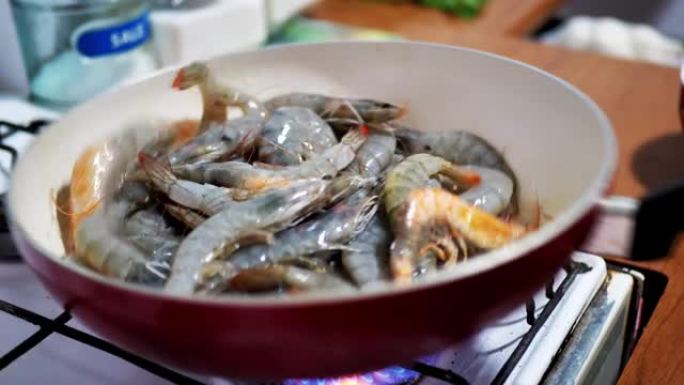 混合的大红虾在平底锅上用热煮油油炸，特写镜头。