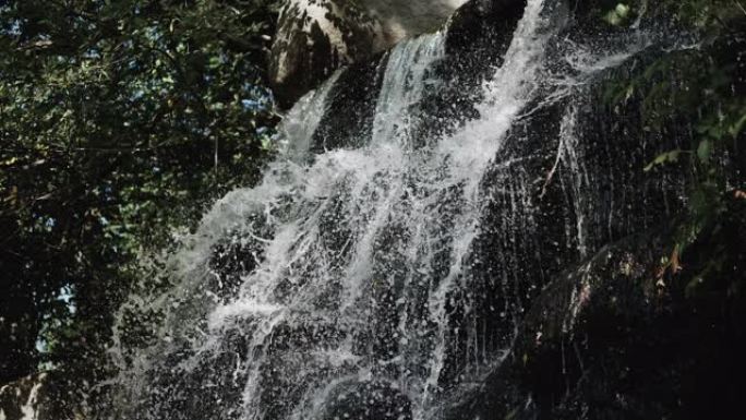 岩石上的瀑布，瀑布上的水飞溅，石头上的溪流，森林中的天然瀑布。