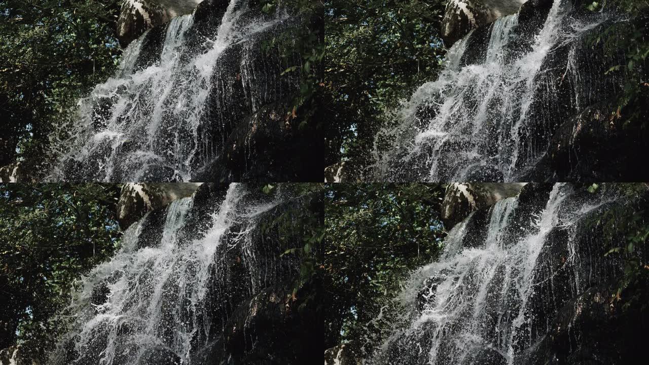 岩石上的瀑布，瀑布上的水飞溅，石头上的溪流，森林中的天然瀑布。