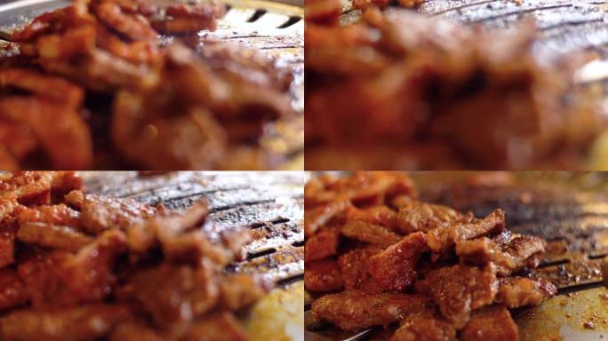 餐厅的韩国烧烤，在热板上烤一片肉的特写镜头。