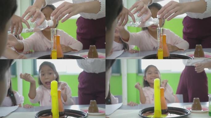 拍摄小组儿童和他们的女教师观察一个科学实验与颜色在一个罐子，教育，科学，技术，儿童和人的概念
