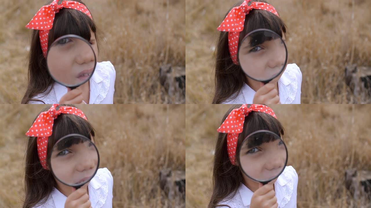 探索世界的孩子。特写四岁好奇的蓝眼睛小女孩穿着白色上衣和圆点红领巾的肖像。透过放大镜看着相机。4k 