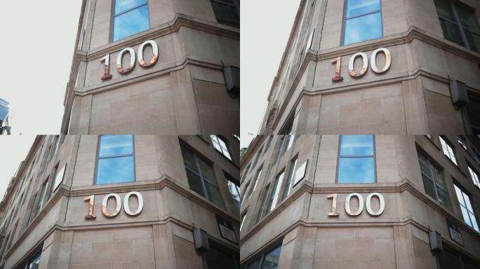 地址编号100在一个灰色建筑的角落的窗户下