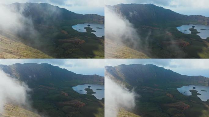 飞越火山顶部的云层。火山口的绿色斜坡和湖泊。卡尔代拉奥、科尔沃、亚速尔群岛