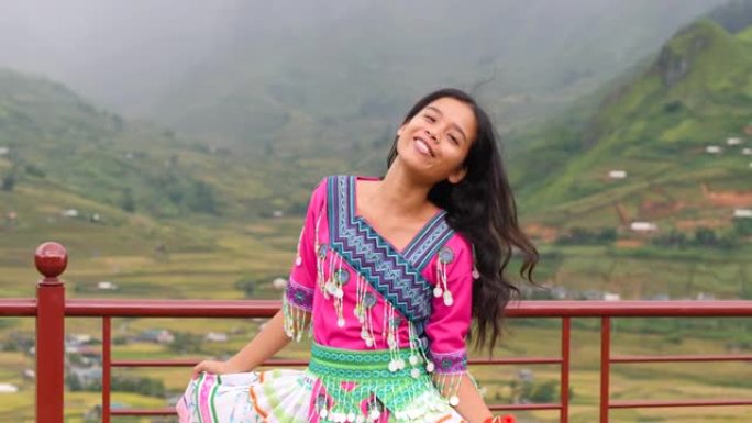 欢快美丽的亚洲女孩穿着五颜六色的文化服装跳舞微笑。