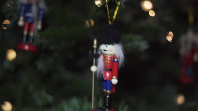 圣诞树上的装饰玩具。胡桃夹子士兵，圣诞树上的老式机器人，背景模糊。美丽装饰的圣诞树，仙女灯