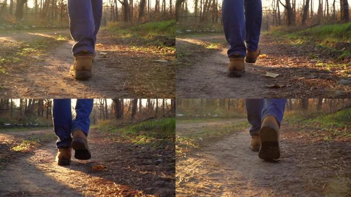 穿着靴子的雄性腿在森林中的小径上行走