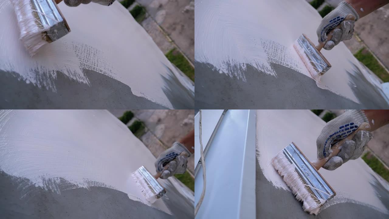 工业登山者用画笔用白色油漆粉刷外墙。慢动作