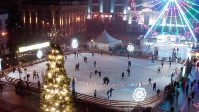 圣诞节和新年前夕，人们在城市广场的溜冰场上滑冰。鸟瞰图。户外放松和娱乐