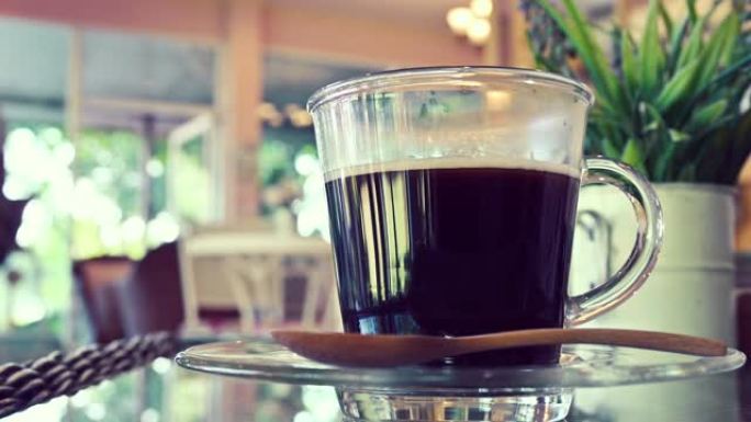 热黑咖啡饮料放在咖啡馆的桌子上，用水蒸汽