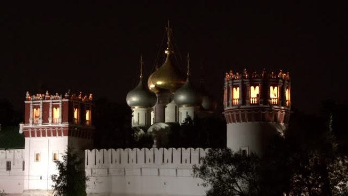 莫斯科新圣母修道院夜晚的塔楼、圆顶和白色石墙。