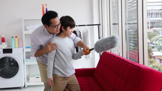 亚洲父亲教儿子在日常琐事中打扫沙发