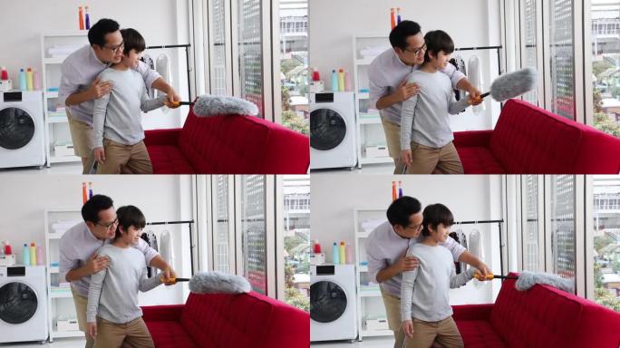 亚洲父亲教儿子在日常琐事中打扫沙发