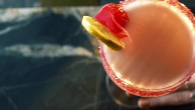 酒吧上令人耳目一新的鸡尾酒的最佳镜头，一只女性的手将鸡尾酒移入框架