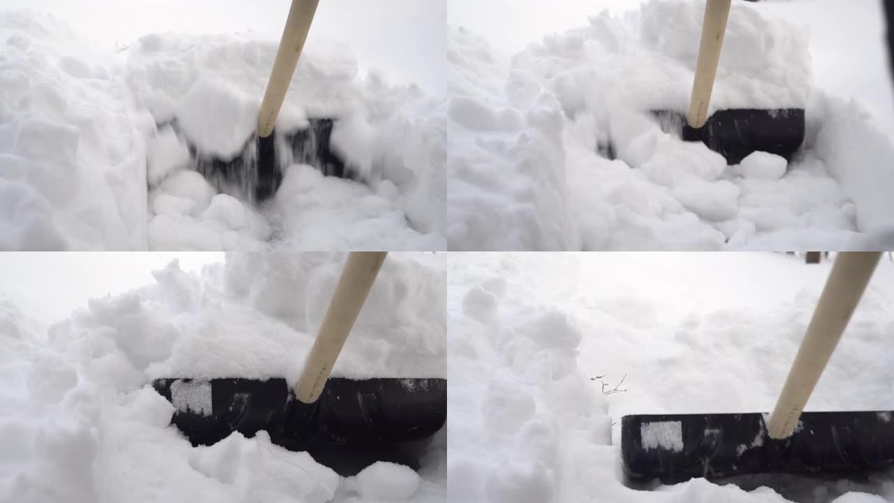 铲子的特写镜头，一个人在院子里用铲子清理雪。俄罗斯的冬天积雪覆盖了院子