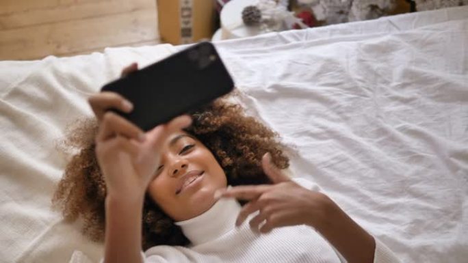 漂亮的黑皮肤博客在床上为博客制作自拍视频