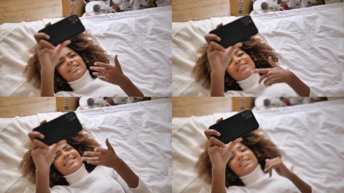 漂亮的黑皮肤博客在床上为博客制作自拍视频