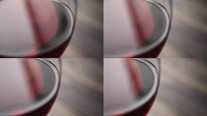 豪华红酒。美味的葡萄酒，由美味的红葡萄在棕色背景的桌子上的酒杯中制成。摄像机向右移动。慢动作。特写