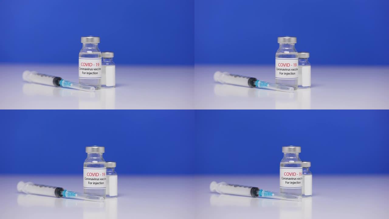 背景实验室桌上的冠状病毒疫苗瓶。注射器特写新型冠状病毒肺炎。击败冠状病毒的概念。蓝屏，色度键。特写。