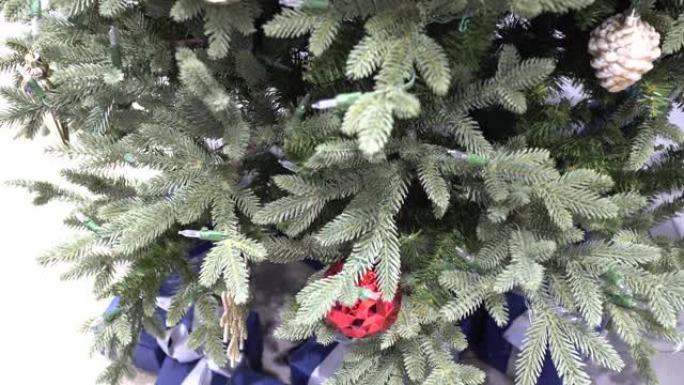 百货公司的圣诞装饰品。圣诞树是绿色的。树下有许多深蓝色的礼物。从上到下倾斜击球。
