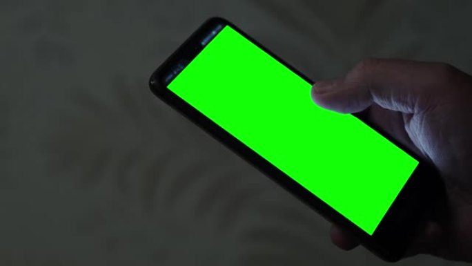 智能手机，绿色屏幕在人的手中。黑屏特写手机。