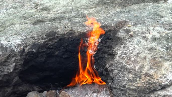 地下甲烷的火焰从岩石之间的裂缝中冒出来，并燃烧到地球