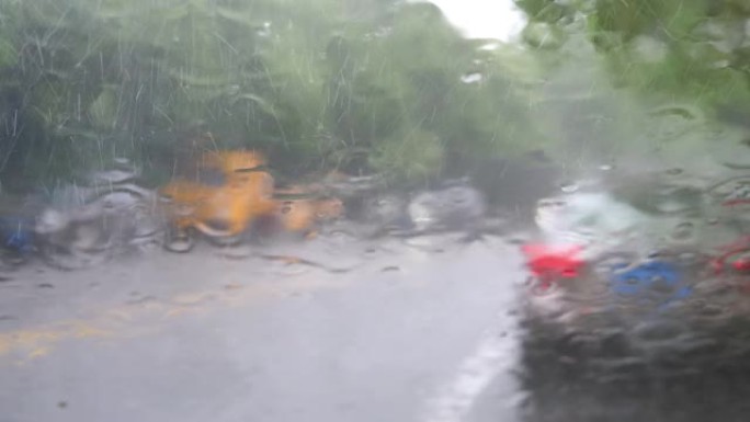 通过带有大雨的车窗观看道路交通，在雨中从汽车挡风玻璃观看交通，4k b滚动镜头，重点是降雨。