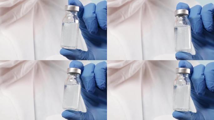 实验室里拿着流感、麻疹、冠状病毒疫苗瓶的蓝色丁腈手套科学家