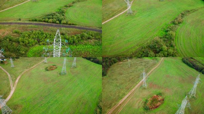 在铁路附近的绿地上，用电线飞过电塔。
