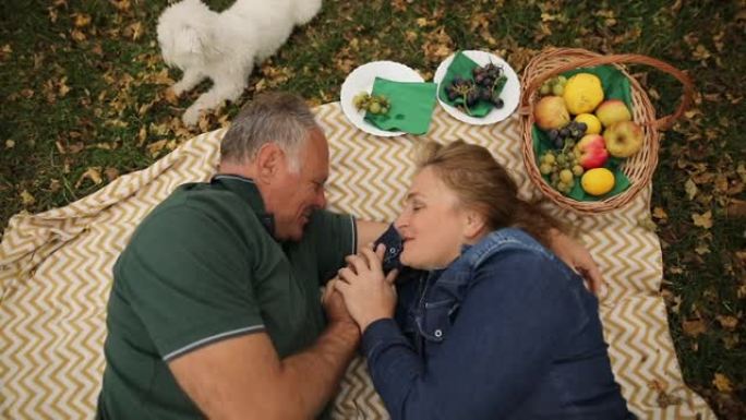 成熟的夫妇和马耳他狗一起享受野餐