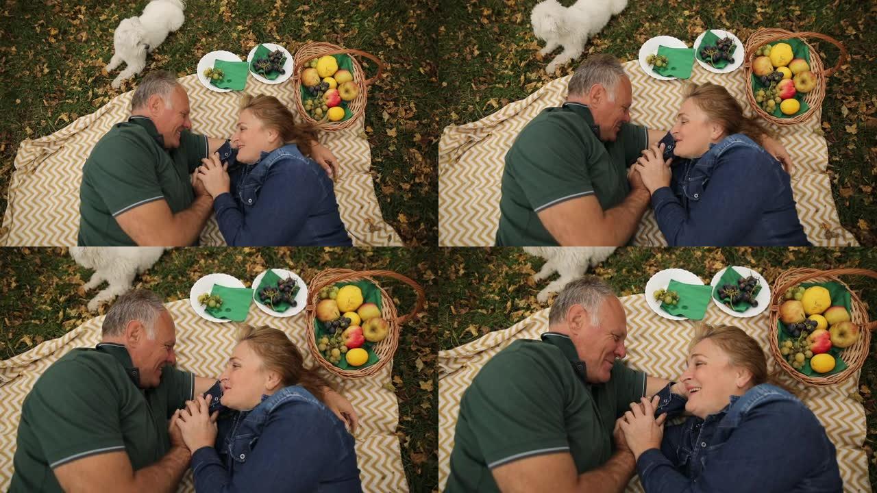 成熟的夫妇和马耳他狗一起享受野餐