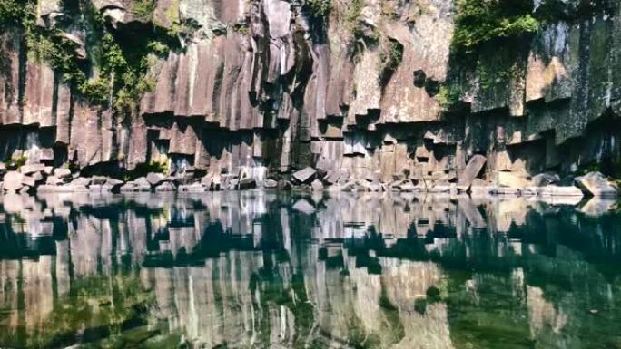 济州岛湖水附近凝固的熔岩。岩石反射在水中。韩国