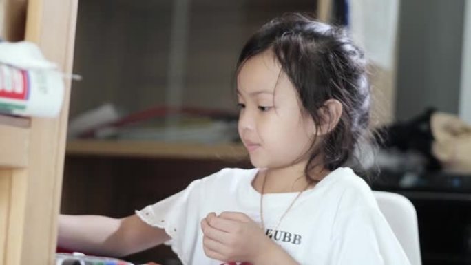 亚洲女孩在家做作业时使用卷笔刀，生活方式理念。