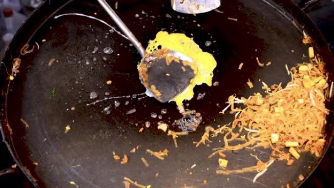 Phad泰国面条，鸡蛋放在扁平的金属炒锅上。