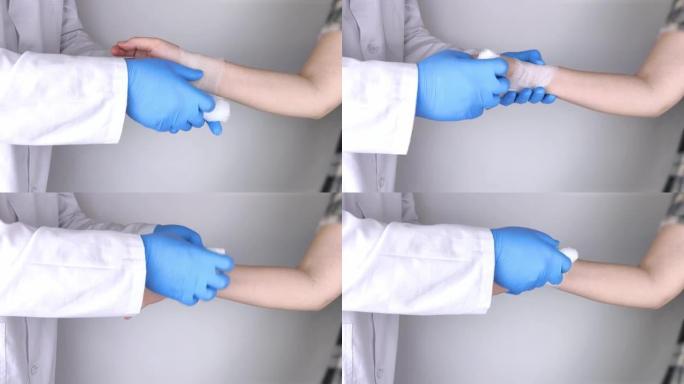 创伤学家在病人的手腕上贴绷带。帮助治疗骨折和扭伤的概念。使用十字形绷带的技术。