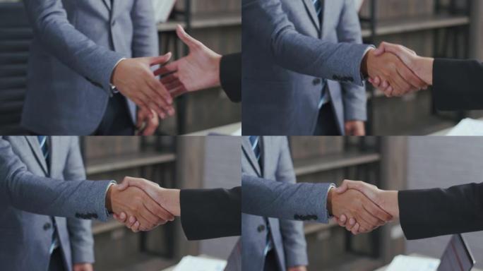 亚洲商人在办公室里站在室内的时候握手合作交易业务，快乐自信的亚洲老板接受握手雇主在新工作中被录用。