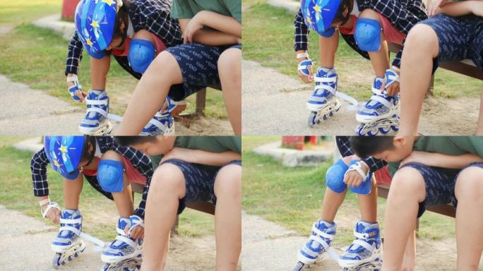 亚洲男孩在早上带着太阳光在公园玩耍之前，为他的妹妹戴着运动头盔。