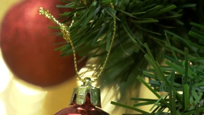 红色泡泡挂在松树上，背景为圣诞灯。