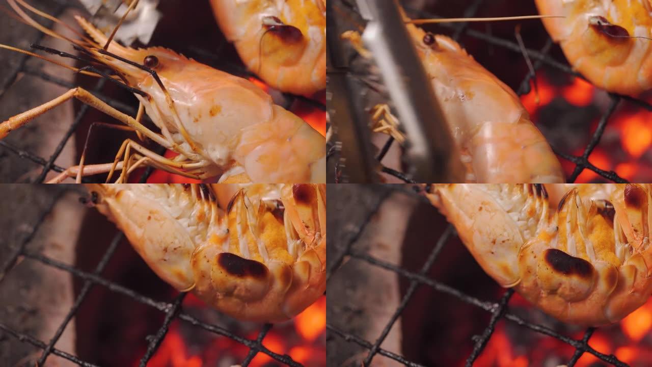 在充满火和火焰的传统炉子上烤虾。泰国和夏季的海鲜菜单。市场，街头食品。美味可口的菜单。宏观拍摄。