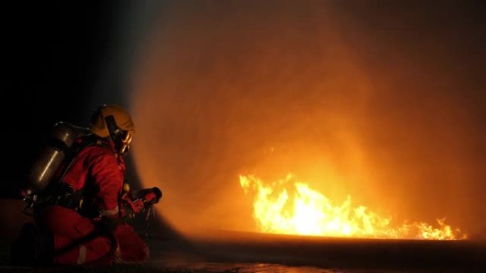 消防员在夜间使用灭火器水进行火灾