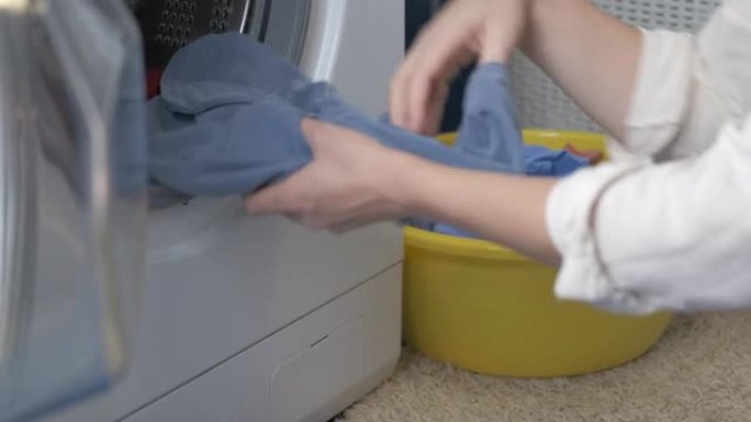 从洗衣机里拿湿衣服。