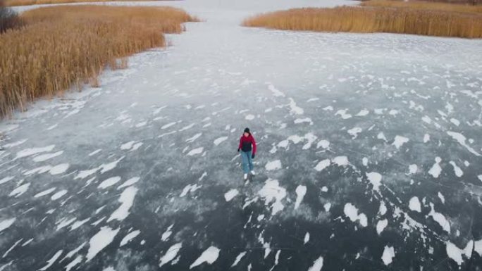 鸟瞰图。一名年轻女子在冰冻的湖上滑冰